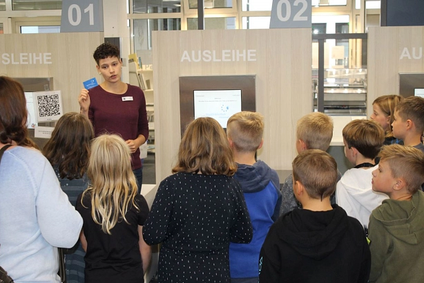 Kinder stehen an der Grundschueler-Ausleihstation in der Stadtbibliothek