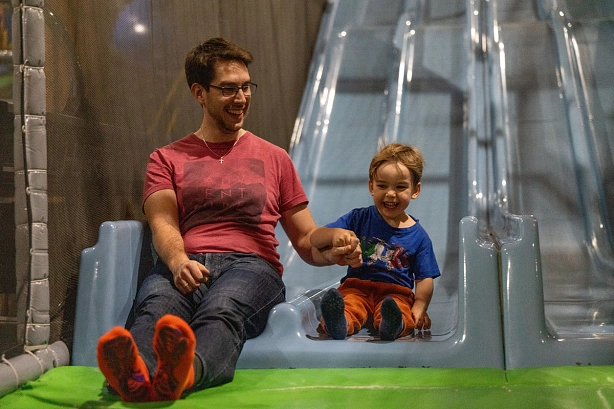 Vater rutscht mit seinem Sohn