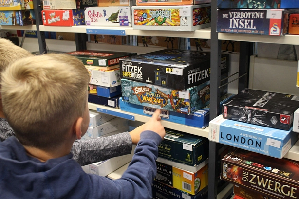 Stadtbibliothek Grundschüler beim Spieleaussuchen